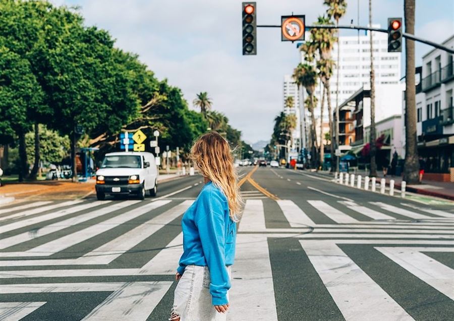 A woman walking across a crosswalk